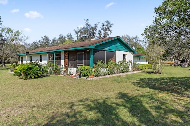 back of property featuring a lawn and a sunroom