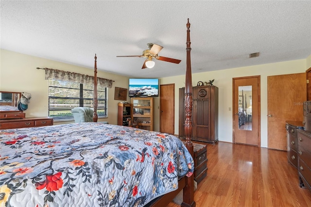 bedroom featuring a textured ceiling, ceiling fan, and wood finished floors