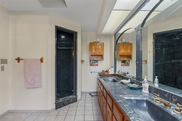 bathroom featuring tile patterned floors, double vanity, baseboards, and a sink