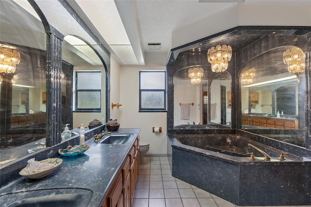 bathroom featuring a textured ceiling, toilet, a chandelier, and a sink