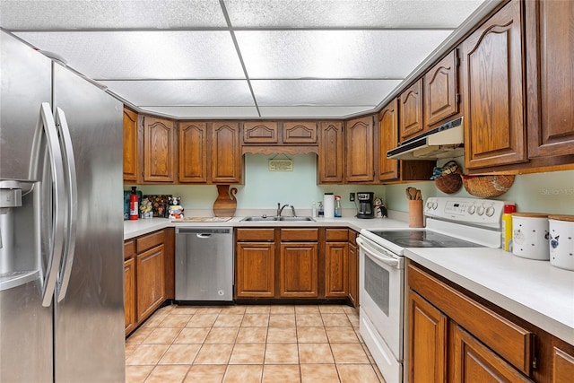 kitchen with a sink, brown cabinets, under cabinet range hood, and stainless steel appliances