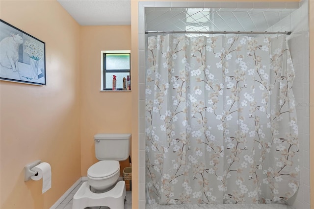 full bathroom featuring tile patterned flooring, toilet, baseboards, and a tile shower