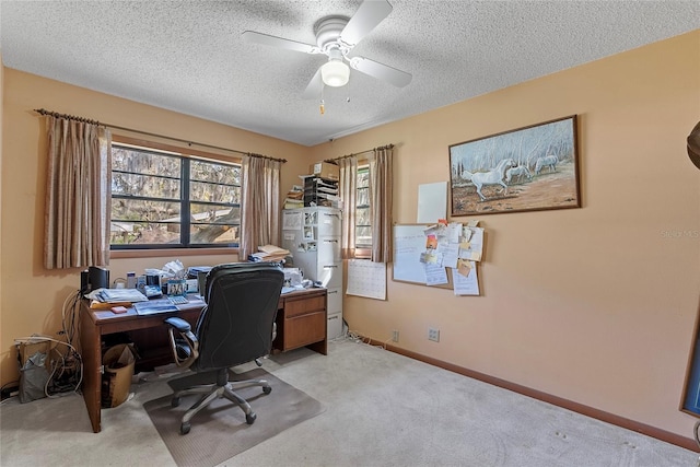 office space featuring baseboards, a textured ceiling, ceiling fan, and carpet