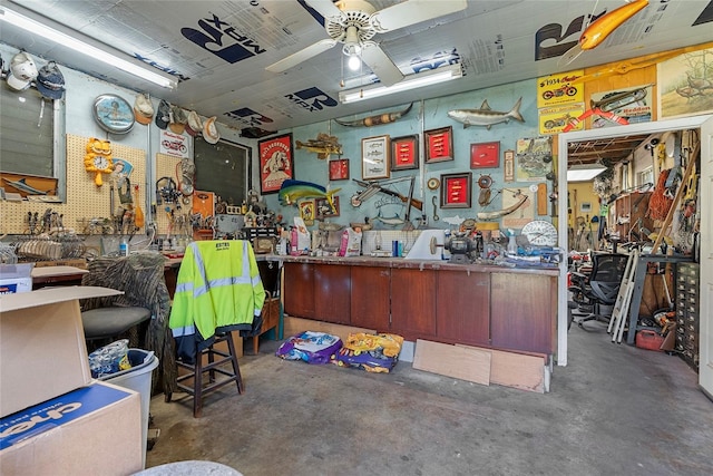 miscellaneous room featuring a workshop area, concrete flooring, and a ceiling fan