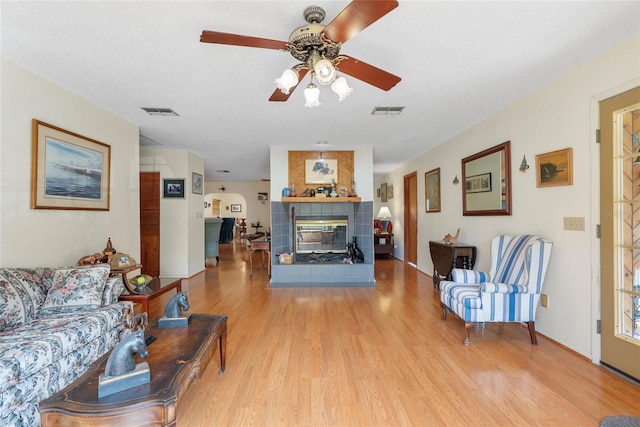 3634 Apfel Rd, Wesley Chapel, FL 33543 - living room with wood finished floors, a tiled fireplace, and a ceiling fan