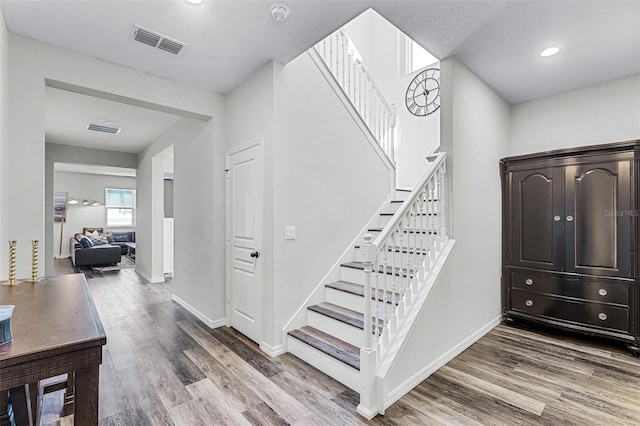 staircase with visible vents, recessed lighting, baseboards, and wood finished floors