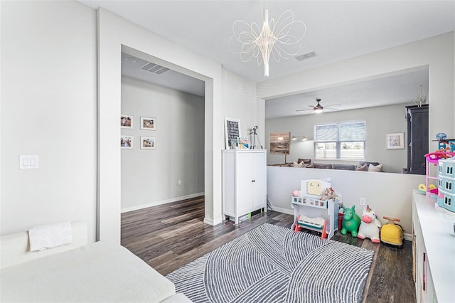 playroom featuring visible vents, ceiling fan with notable chandelier, baseboards, and wood finished floors