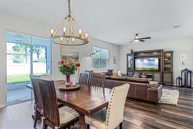 dining area featuring plenty of natural light, ceiling fan with notable chandelier, visible vents, and wood finished floors