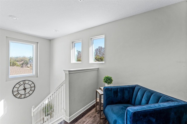 sitting room featuring wood finished floors, plenty of natural light, an upstairs landing, and baseboards