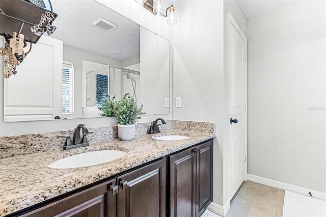 full bathroom featuring a sink, visible vents, a stall shower, and double vanity