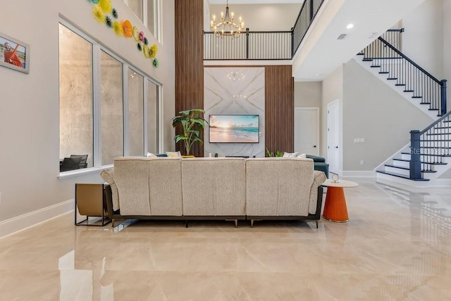 living room with baseboards, stairs, an inviting chandelier, and a towering ceiling