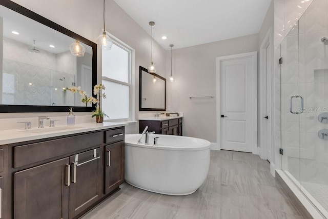 full bath with two vanities, a stall shower, a sink, recessed lighting, and a soaking tub