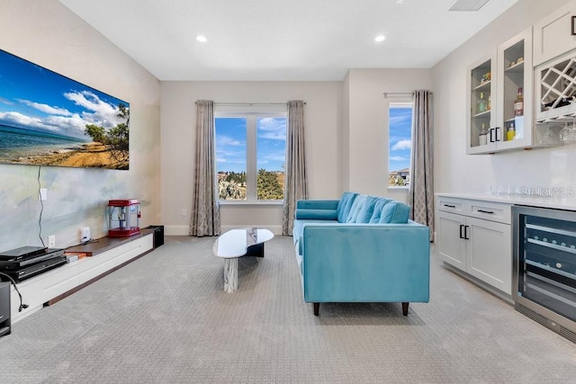 living room with light carpet, beverage cooler, recessed lighting, baseboards, and a dry bar