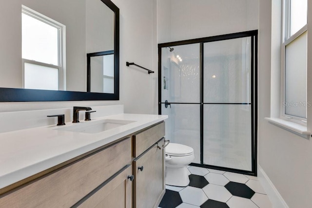 full bathroom with vanity, toilet, baseboards, and a stall shower