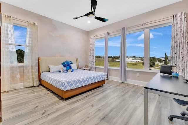 bedroom featuring baseboards, wood finished floors, and a ceiling fan