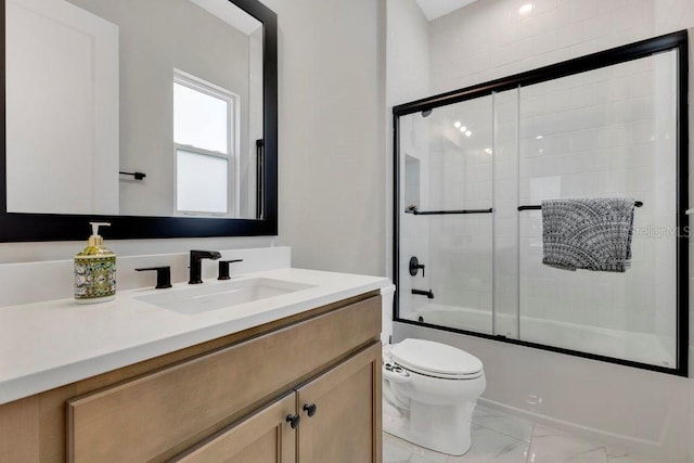 full bath with vanity, toilet, marble finish floor, and bath / shower combo with glass door