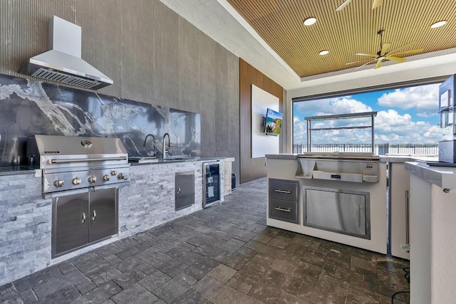 view of patio featuring a ceiling fan, an outdoor kitchen, a sink, wine cooler, and grilling area