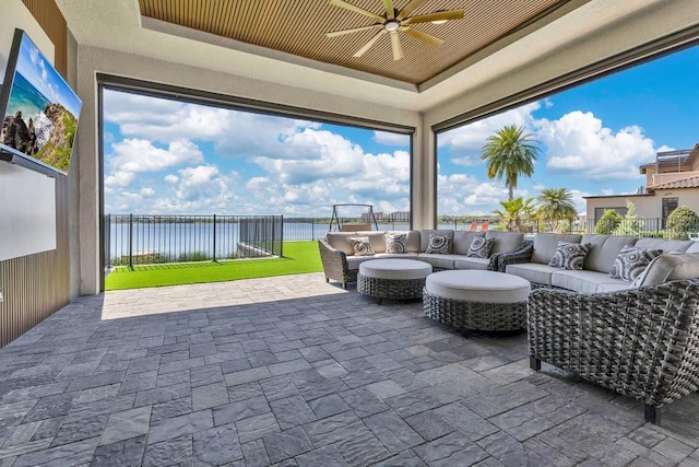 view of patio / terrace featuring an outdoor living space, a water view, a fenced backyard, and a ceiling fan