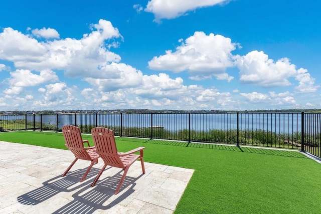 view of patio / terrace featuring a water view and fence