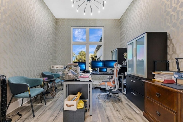 home office featuring wallpapered walls, baseboards, light wood finished floors, and a chandelier