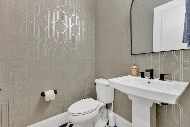 bathroom featuring wallpapered walls and toilet