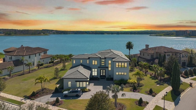 aerial view at dusk featuring a water view