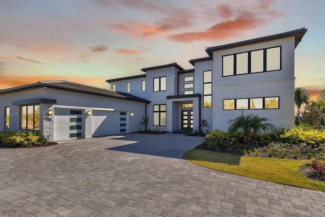 contemporary home featuring stucco siding, driveway, and an attached garage