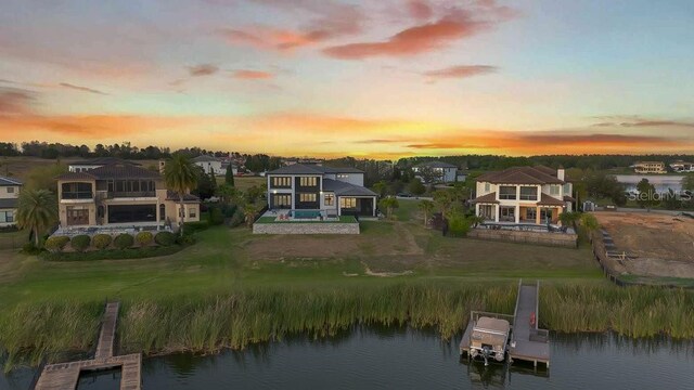 aerial view at dusk with a residential view and a water view