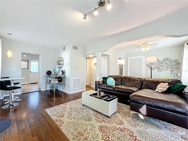 living area featuring arched walkways, visible vents, ceiling fan, and hardwood / wood-style floors