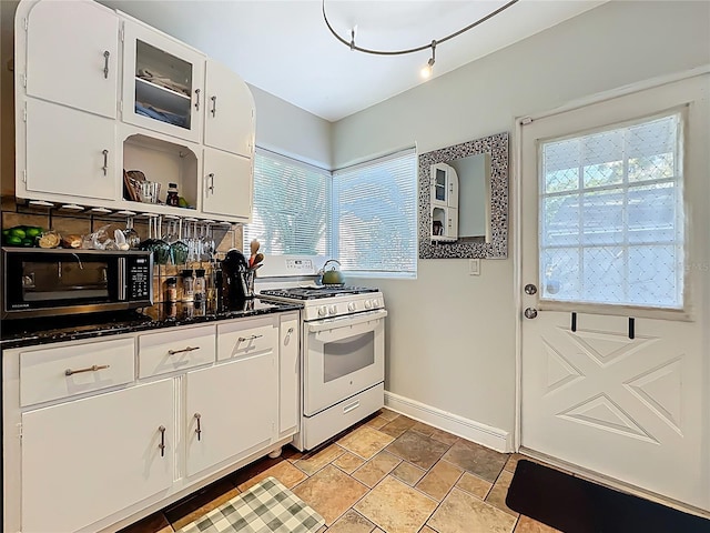 kitchen featuring white gas range, backsplash, white cabinetry, and open shelves