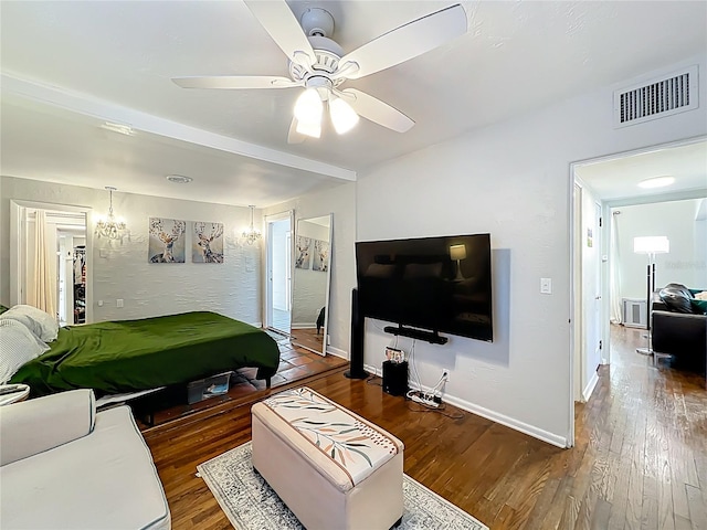 bedroom featuring visible vents, a ceiling fan, baseboards, and wood finished floors