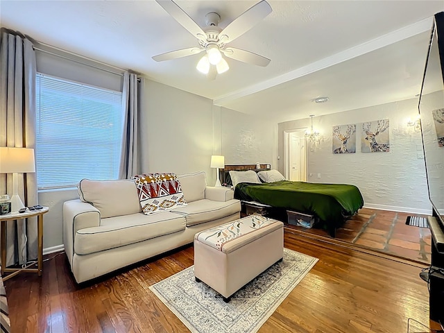 bedroom featuring wood finished floors, a ceiling fan, and a textured wall