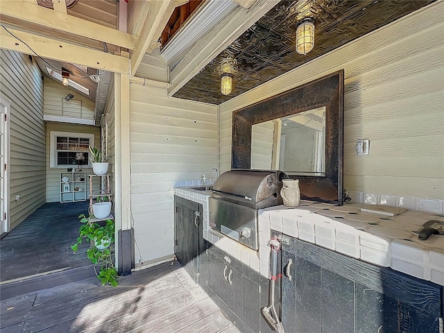 laundry area with wood walls, light wood-style flooring, and a sink