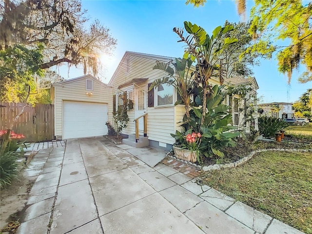 view of front of house with fence, entry steps, concrete driveway, an outdoor structure, and crawl space