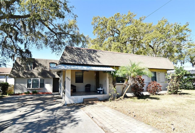 view of front facade featuring concrete driveway and a porch