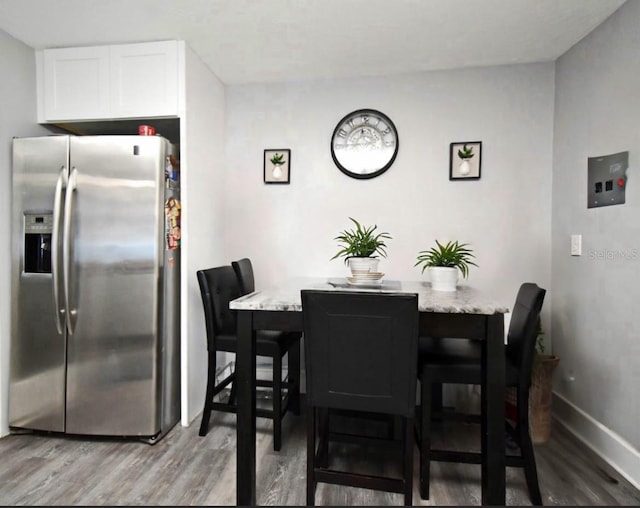 dining space featuring baseboards and light wood finished floors