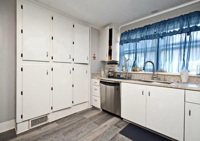 kitchen with visible vents, a sink, white cabinets, stainless steel dishwasher, and a wealth of natural light