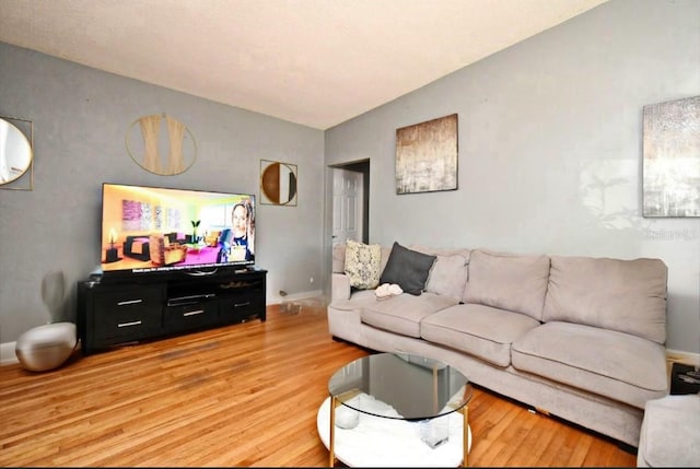 living area featuring light wood-style flooring and baseboards