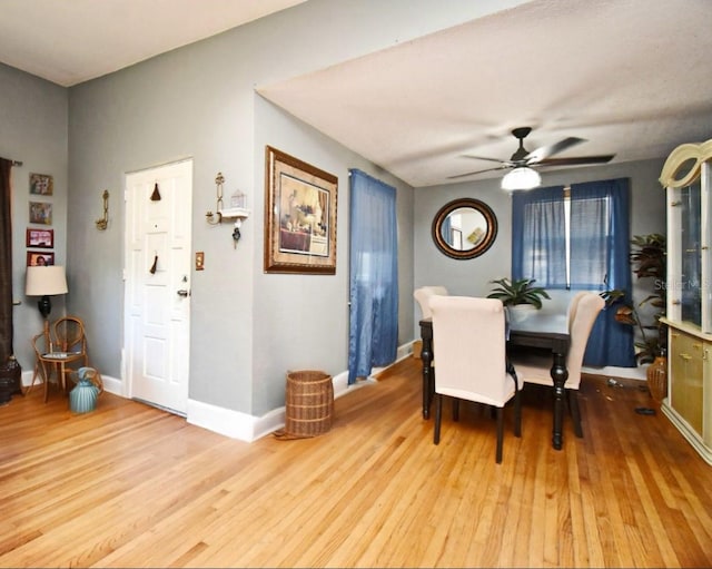 dining area with baseboards, wood finished floors, and a ceiling fan