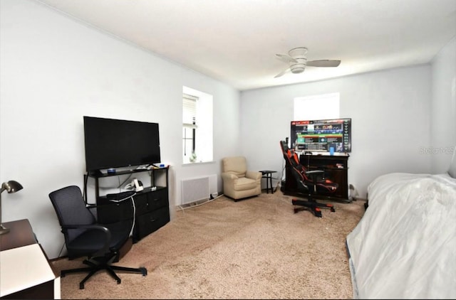 carpeted home office with a ceiling fan and visible vents