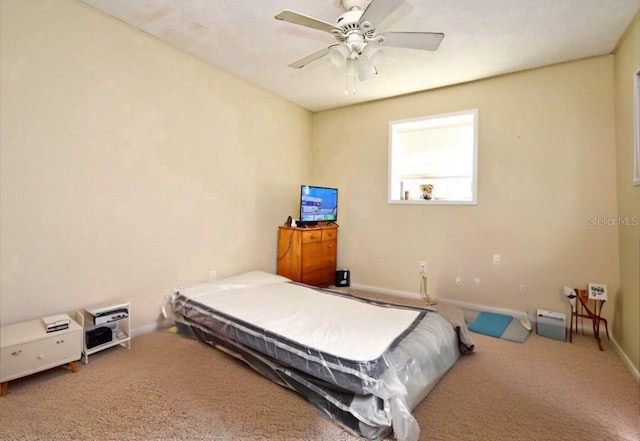 carpeted bedroom featuring baseboards and ceiling fan