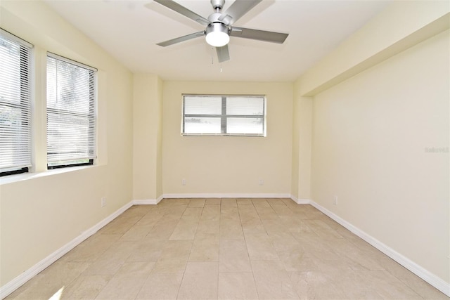 spare room featuring a wealth of natural light, ceiling fan, and baseboards