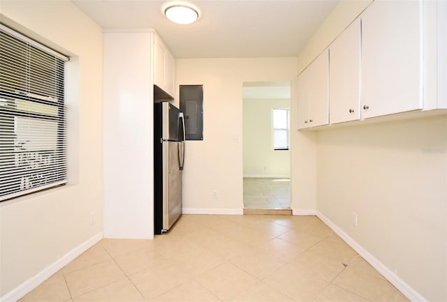 spare room featuring light tile patterned floors and baseboards