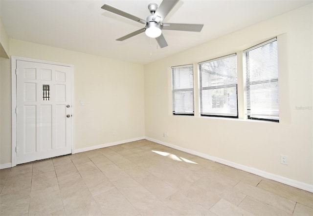 spare room featuring baseboards and a ceiling fan