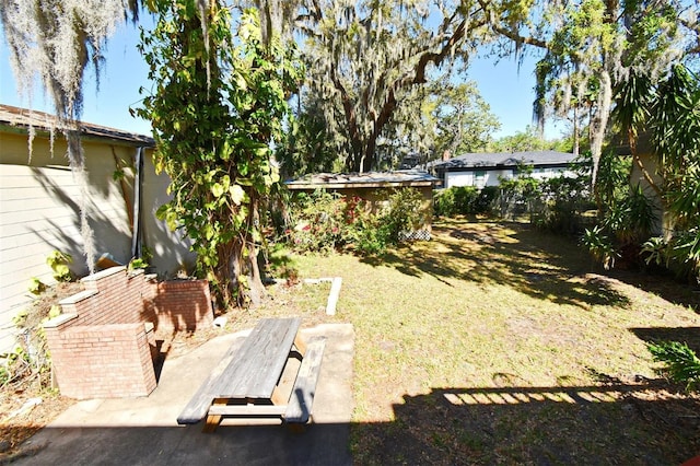 view of yard with a storage shed, an outbuilding, and fence