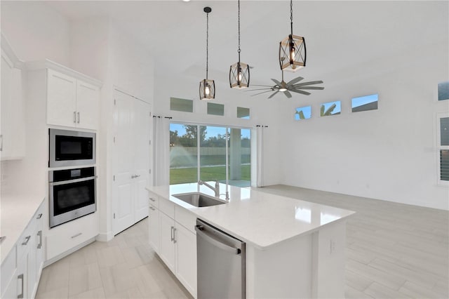 kitchen featuring a sink, ceiling fan, stainless steel appliances, and open floor plan