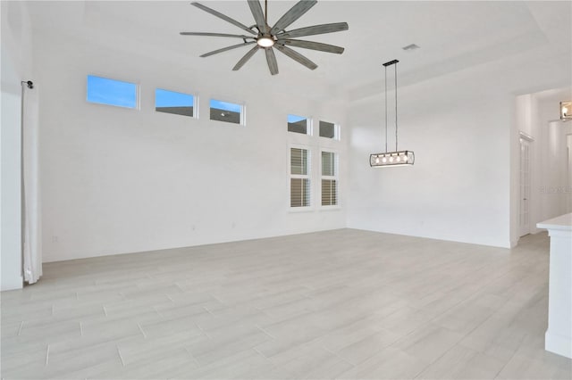 empty room featuring a ceiling fan, light wood-style flooring, and visible vents