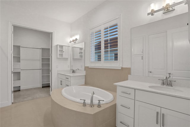 bathroom featuring tile patterned flooring, two vanities, a sink, and a bath