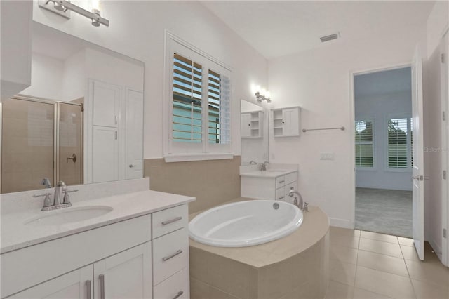 bathroom with visible vents, a bath, tile patterned floors, a sink, and a stall shower