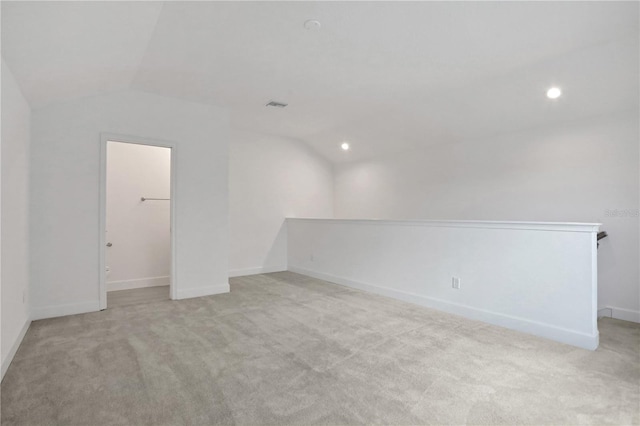 unfurnished room featuring visible vents, vaulted ceiling, baseboards, light carpet, and recessed lighting